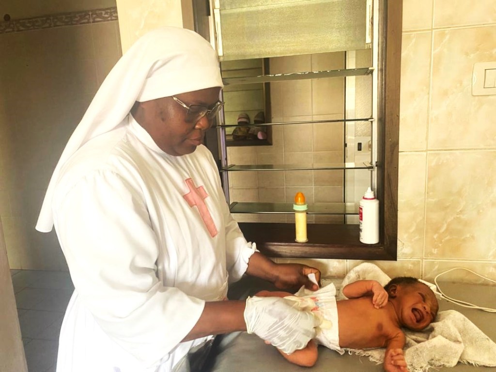 Kamillianische Schwester bei der Krankenpflege eines Neugeborenen